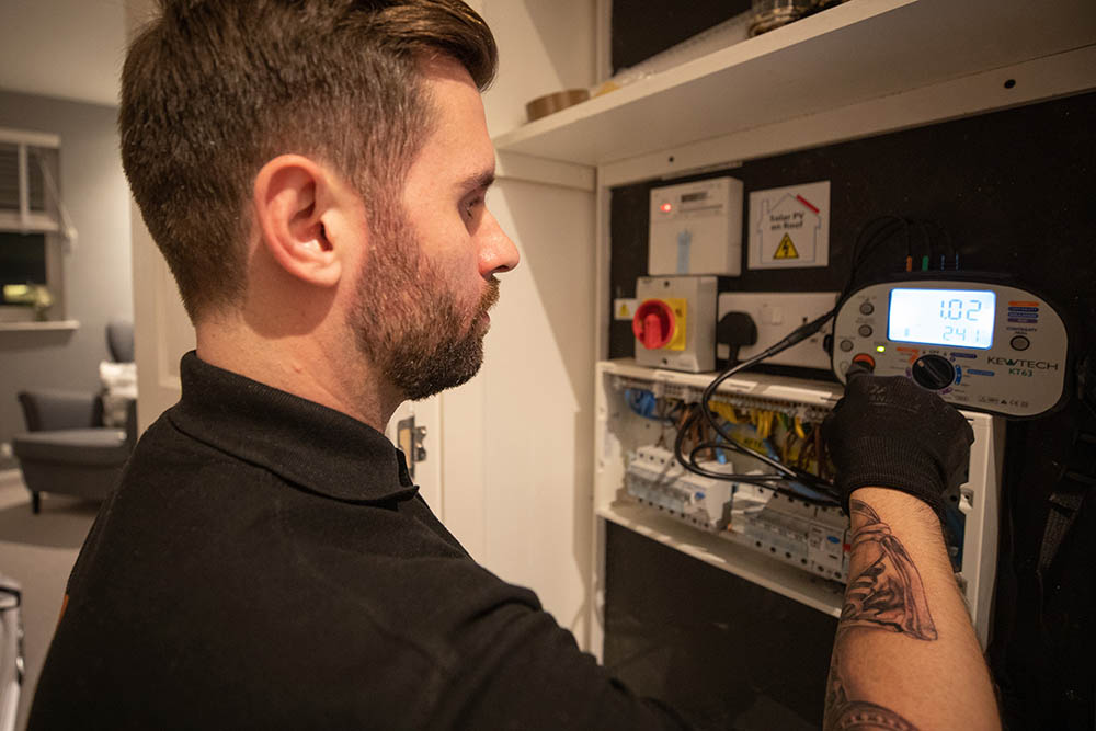 Electrician carrying out checks on an RCD unit in a house in Edinburgh